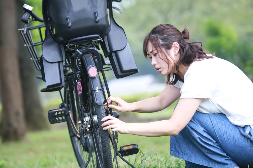 自転車が故障して困っている女性